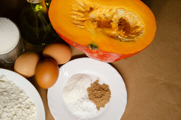 Concept homemade fall baking with pumpkin and food ingredients. Cooking pumpkin pie. Ripe pumpkin, flour, eggs, spices, baking powder, sugar, oil. Step by step instructions. Step 2.