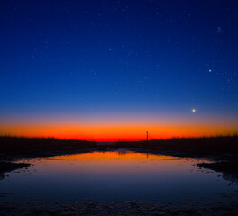small quiet lake at the twilight under a starry sky