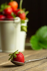 juicy strawberries on a spoon and a wooden background. High quality photo
