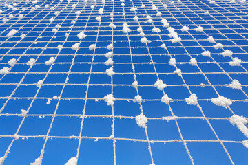 Volleyball net covered with snow. Nature's minimalism. 