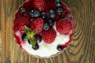 raspberries and blueberries in yogurt sauce in kremanka, top view. Juicy raspberries and blueberries. High quality photo