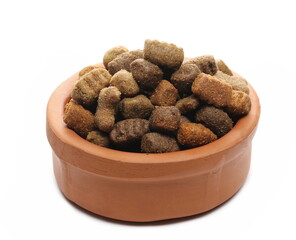 Dry dog food in clay pot, granules isolated on white background