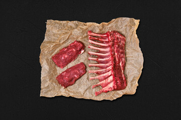 Top view of raw fresh rack of lamb and steak in wrapping paper