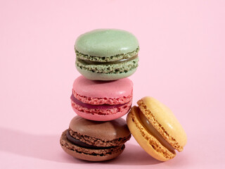 Sweet chocolate macarons, on a pink background.