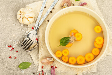Transparent chicken broth with vegetables and spices