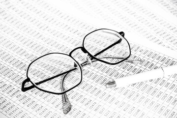 finance business calculation with glasses, tables with numbers and pen. business concept. financial literacy. accounting of income and expenses