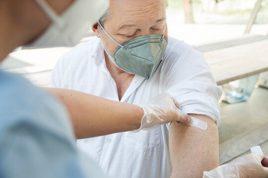Austria, Vienna, Close-up of nurse applying adhesive bandage on patients arm