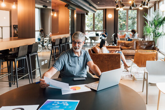 Italy, Businessman working at table in creative studio