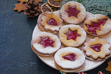 Homemade Christmas cookies with raspberry jam. Traditional Linzer cookies on a dark table, copy space