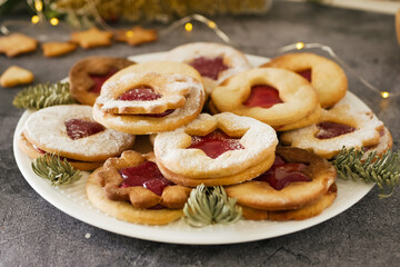 Delicious homemade Christmas cookies with jam, copy space. Traditional Linzer cookies on a dark table, copy space