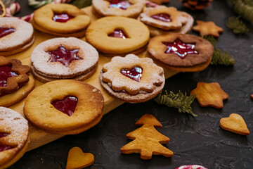 Homemade Christmas cookies with raspberry jam. Traditional Linzer cookies on a dark table, copy space