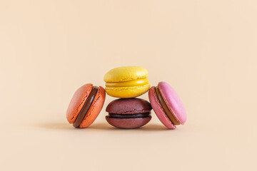 Tasty french macarons on a yellow pastel background.