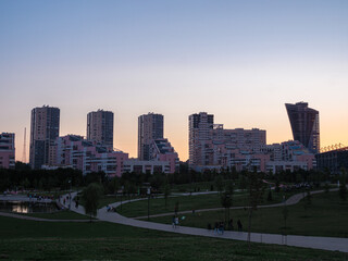 Fototapeta na wymiar Park and residential skyscrapers at Khodynskoe field at sunset