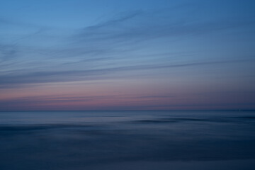 Sunset at sea, light blue sky, dusk