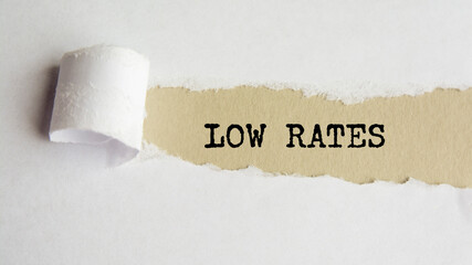 LOW RATES. words. text on gray paper on torn paper background