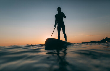 Low angle view of  man silhouette paddling SUP board