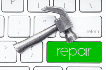 Small steel hammer on a keyboard. Repair concept.
