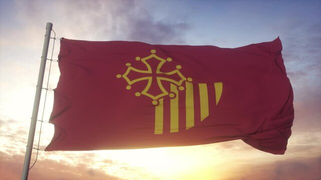 Languedoc-Roussillon flag, France, waving in the wind, sky and sun background