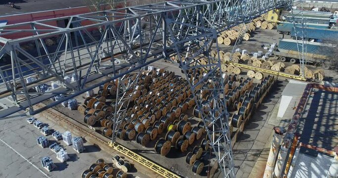 Gantry crane in a factory warehouse, reels with cables, under a gantry crane