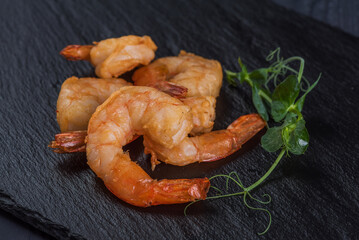 Fried prawns on a black stone tray. Seafood