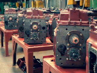 Transmission gearboxs in the shop of the tractor factory, selective focus. Gear boxes production....