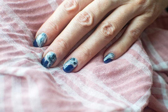 Blue manicure with beautiful stains and silver glitters.
