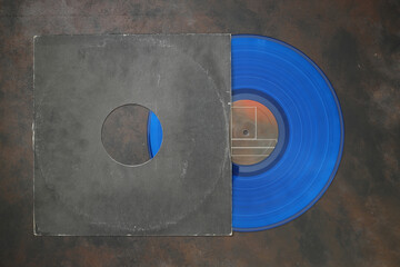 Aged black paper cover and blue vinyl LP record isolated on rusty background	
