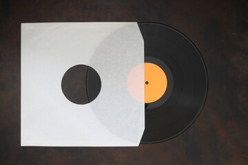 Aged White paper cover and   vinyl LP record isolated on rusty background	