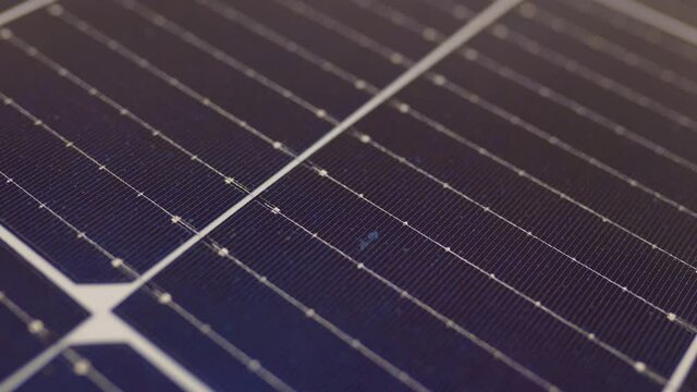 Macro shoot of modern photovoltaic solar battery panels. Ecology and environment protection concept. Renewable green energy. Solar panels close-up. Solar panels slow motion. Solar panels moving shot.