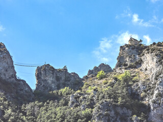 Paysage de montagne dans le Sud de la France avec une chapelle et un passerelle en bois