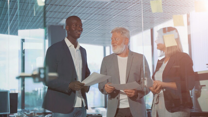 three diverse business workgroup team with african man leader discuss paperwork financial report statistical data, Brainstorm, briefing activity concept