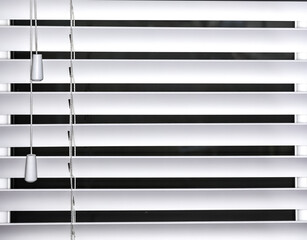 Horizontal venetian blinds in white with pull cord close up