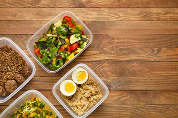 Containers with healthy food on wooden background