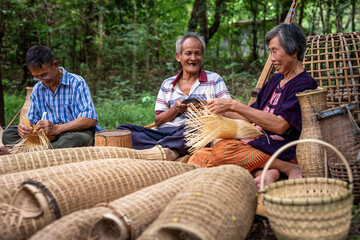 Happy Asian elderly weave from bamboo by hand. Handicrafts of local elderly people, Thailand