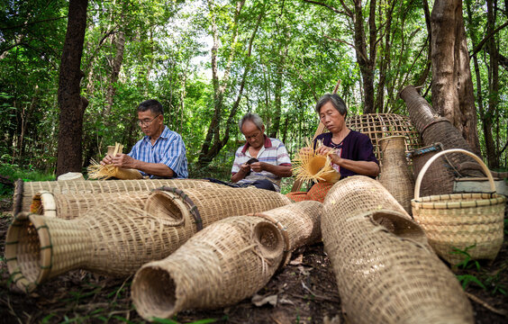 Asian elderly man and woman gathered together to weave from bamboo by hand. Handicrafts of local elderly people, Thailand