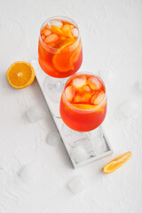 Glasses of Aperol spritz cocktail on light background