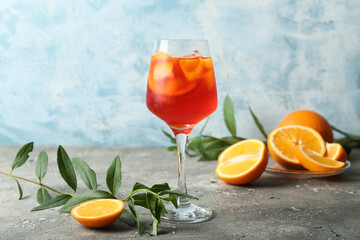 Glass of Aperol spritz cocktail on grey background
