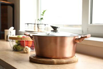 Copper cooking pot on table in kitchen