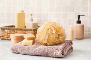 Towel, soap and soft bath sponge on table