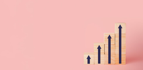 Wood block cubes stacking as step stair with arrow up on pink background, Business concept growth success process.
