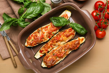 Composition with meat stuffed zucchini boats on color wooden background