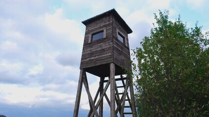 Wooden Hunting Pulpit Tower at the Edge of Forest Clearing	

