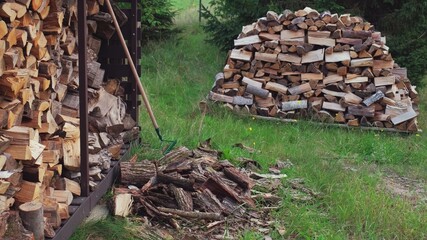 Chopped Logs of Wood For Fireplace Stored Outdoors before Winter Season in Simple Metal Woodshed	
