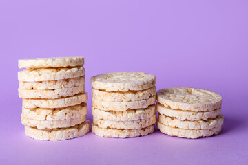 Stacks of crispy rice crackers on purple background