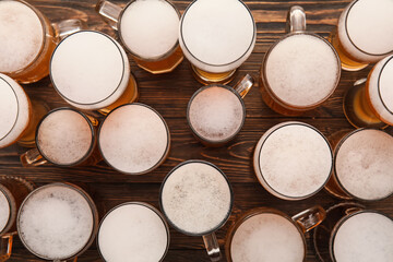 Mugs and glasses of cold beer on wooden background. Oktoberfest celebration