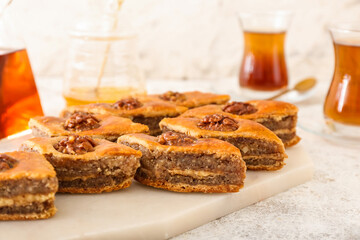 Board with tasty baklava on table, closeup