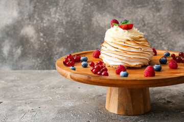 Dessert stand with tasty Pavlova cake on grunge background