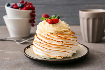 Plate with tasty Pavlova cake on grunge background