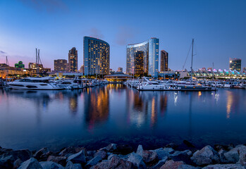Beautiful twilight mood at the San Diego Marina, with yachts and the Marriott Marquis hotel reflected in the water - obrazy, fototapety, plakaty