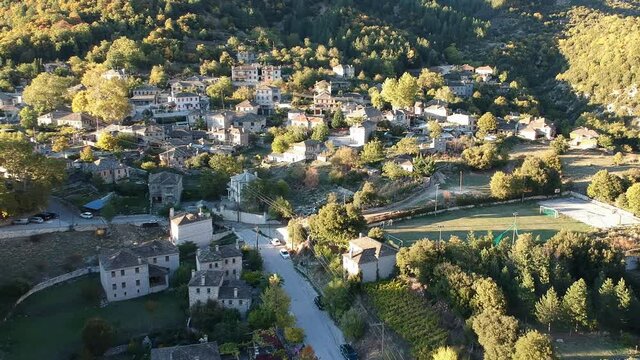 Aerial panoramic view over the picturesque village Papigo in Epirus, Greece at sunset. Scenic aerial view of traditional Greek villages in Autumn. Epirus, Greece, Europe.